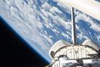 In this handout image provided by NASA, backdropped by a blue and white Earth and the blackness of space, a partial view of Space Shuttle Endeavour's payload bay, vertical stabilizer and orbital maneuvering system (OMS) pods are seen July 16, 2009 in Space.