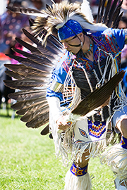 Photo of a Native American dancer in beautiful regalia "looking for tracks" as he dances.  This photo was taken by Brian Tramontana at the West Valley College 20th Annual Powwow.