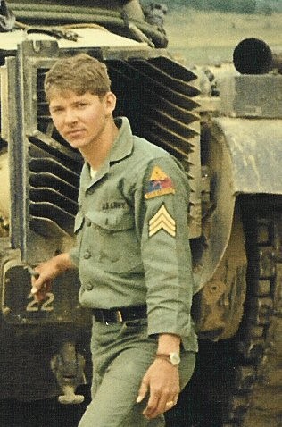 Jim Smith standing next to a tank